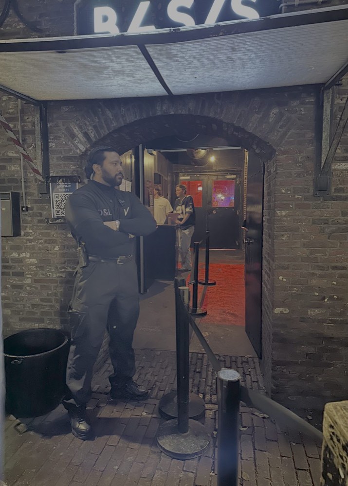 Beveiliger van D&L Security Services bij een clubingang in de nacht